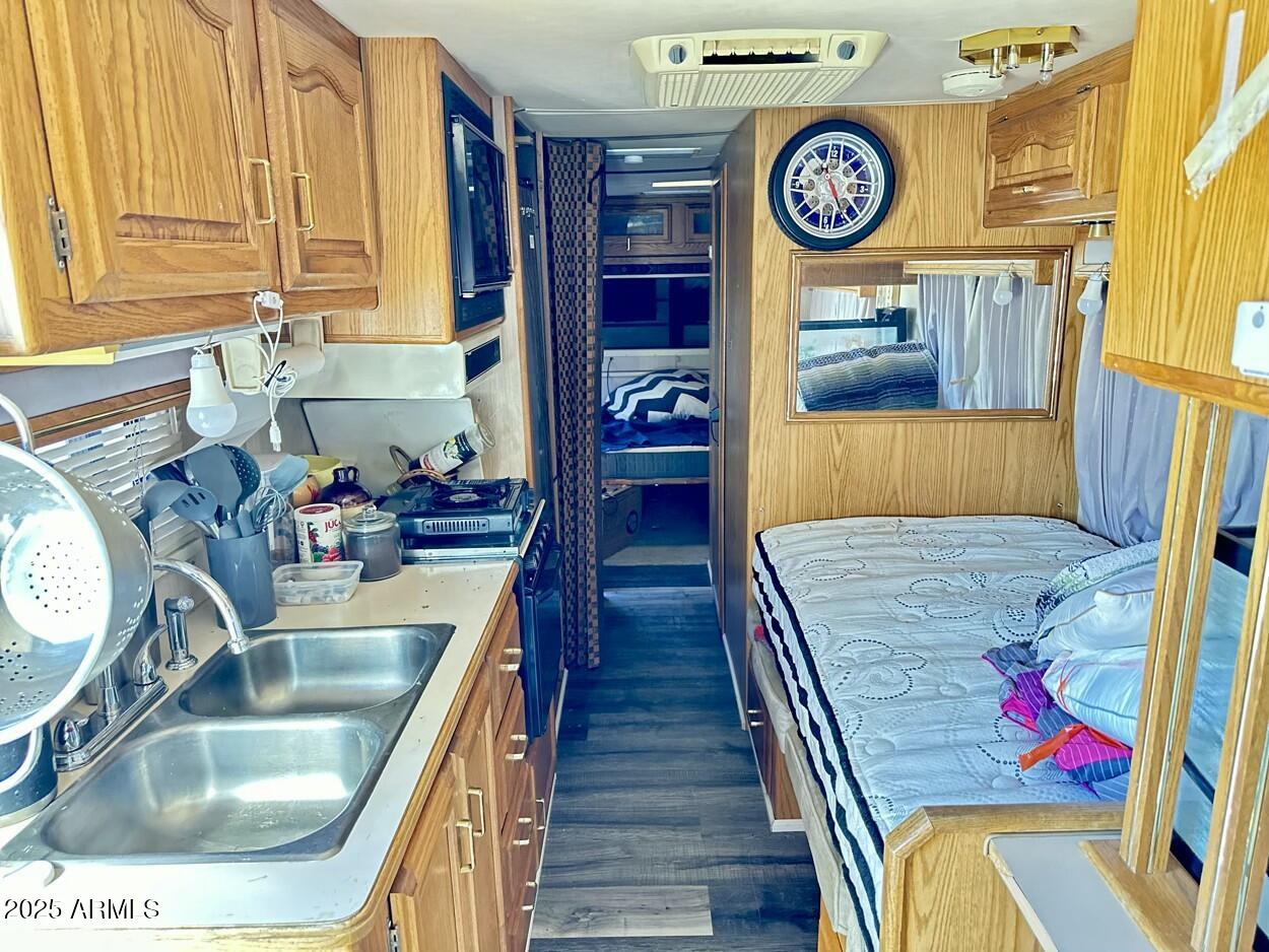 0 South Burro Pass Road, Unit 76 Morristown, AZ 85342 - Photo 11 of 18 a kitchen with wooden cabinets and a sink