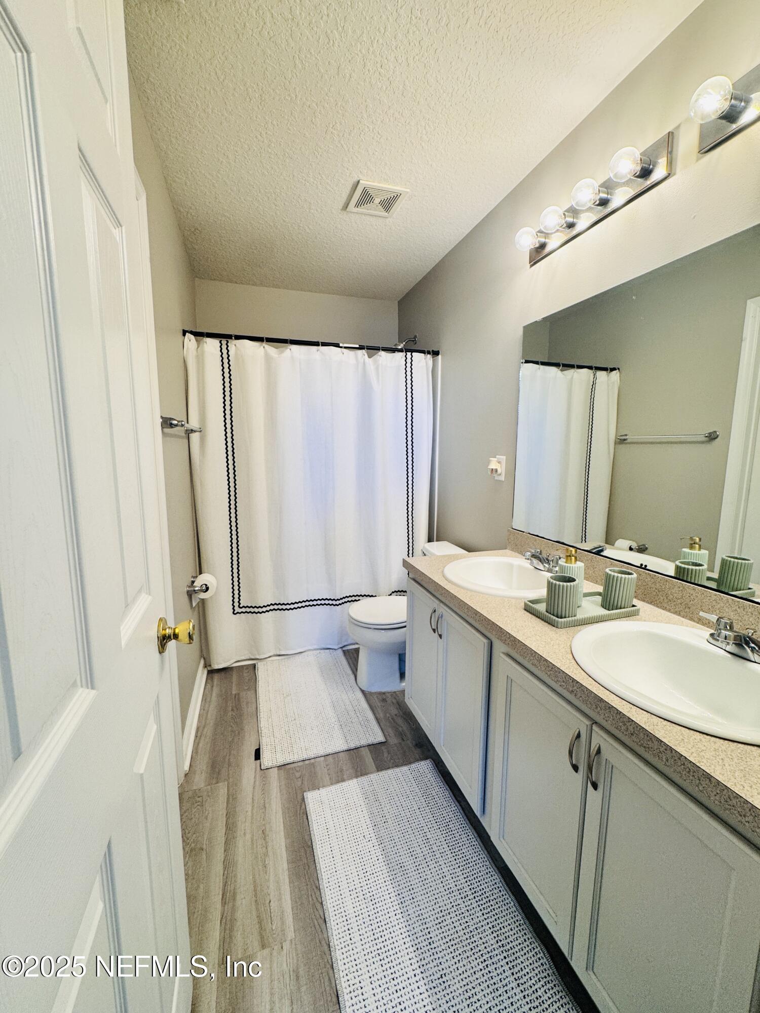 8882 Shell Island Drive Jacksonville, FL 32216 - Photo 14 of 15 a bathroom with a double vanity sink toilet and shower