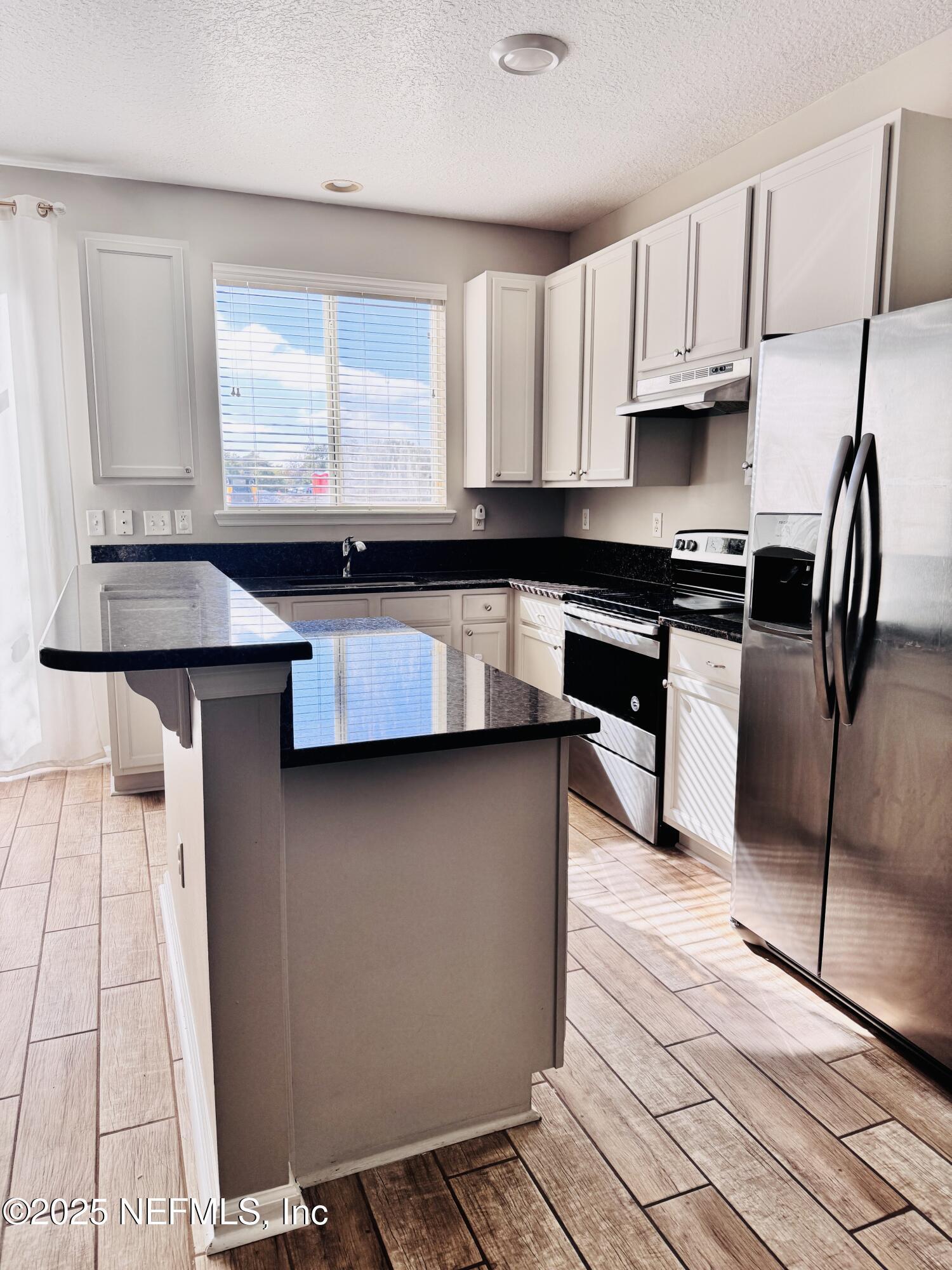 8882 Shell Island Drive Jacksonville, FL 32216 - Photo 5 of 15 a kitchen with stainless steel appliances granite countertop a stove a sink and a microwave