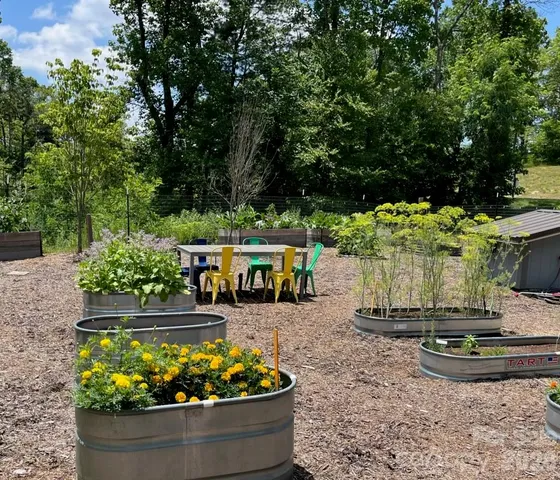 a sign that is sitting in front of a tree