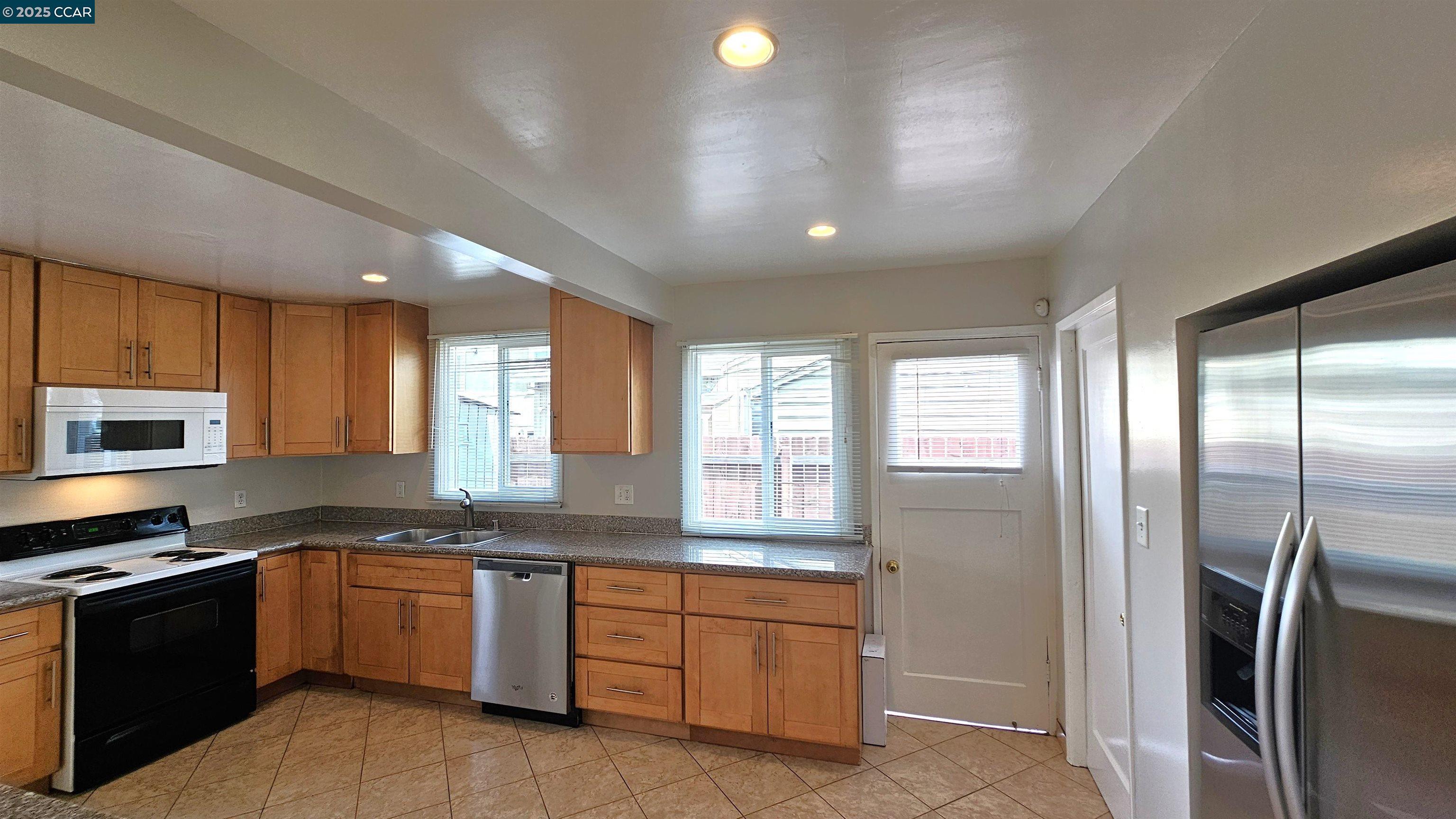2475 Maple Avenue Concord, CA 94520 - Photo 12 of 28 a large kitchen with granite countertop a refrigerator a sink a stove and cabinets