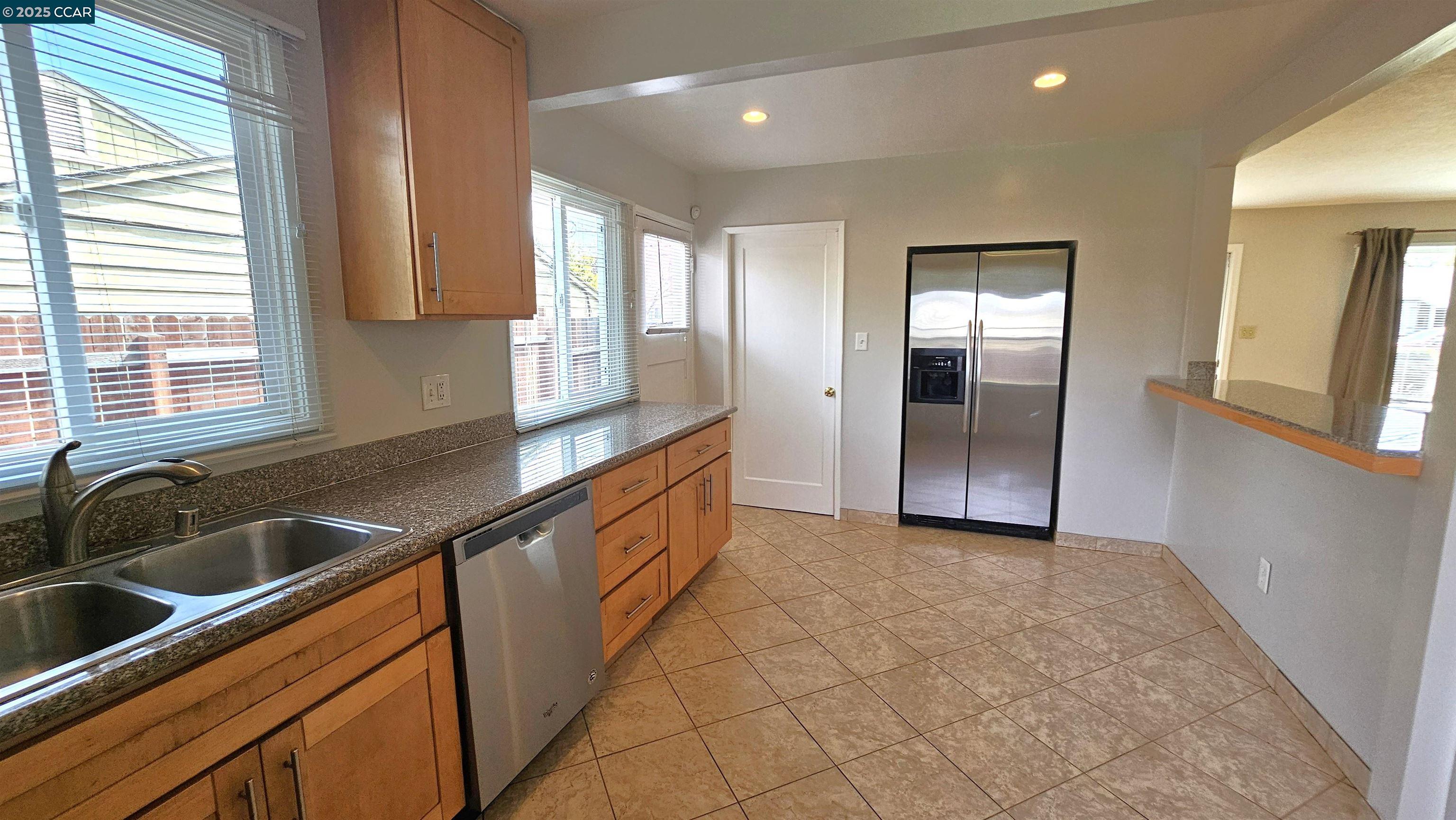 2475 Maple Avenue Concord, CA 94520 - Photo 13 of 28 a kitchen with granite countertop a sink and a refrigerator