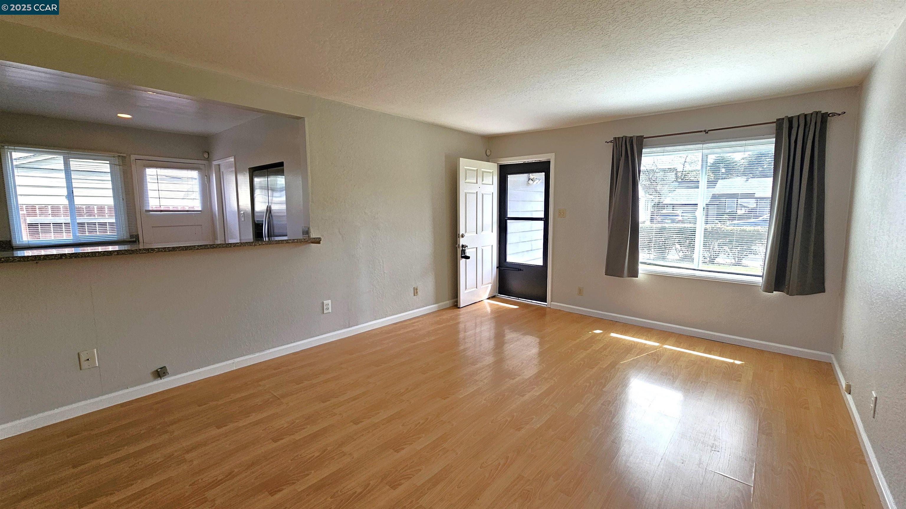 2475 Maple Avenue Concord, CA 94520 - Photo 7 of 28 an empty room with wooden floor and windows