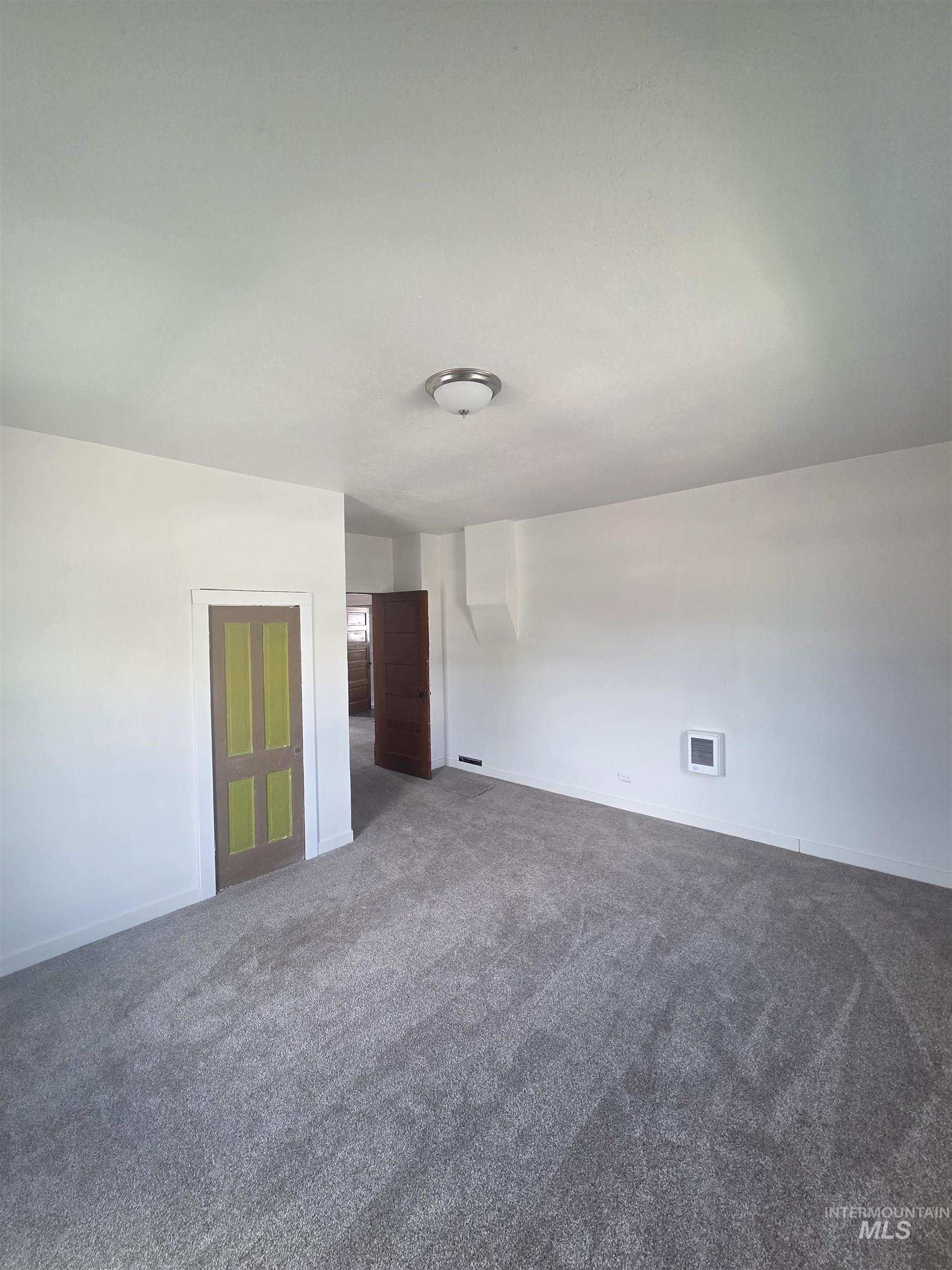 986 Columbia Street Pomeroy, WA 99347 - Photo 12 of 20 Spacious room featuring light gray carpeting, white walls, and a contemporary ceiling light fixture