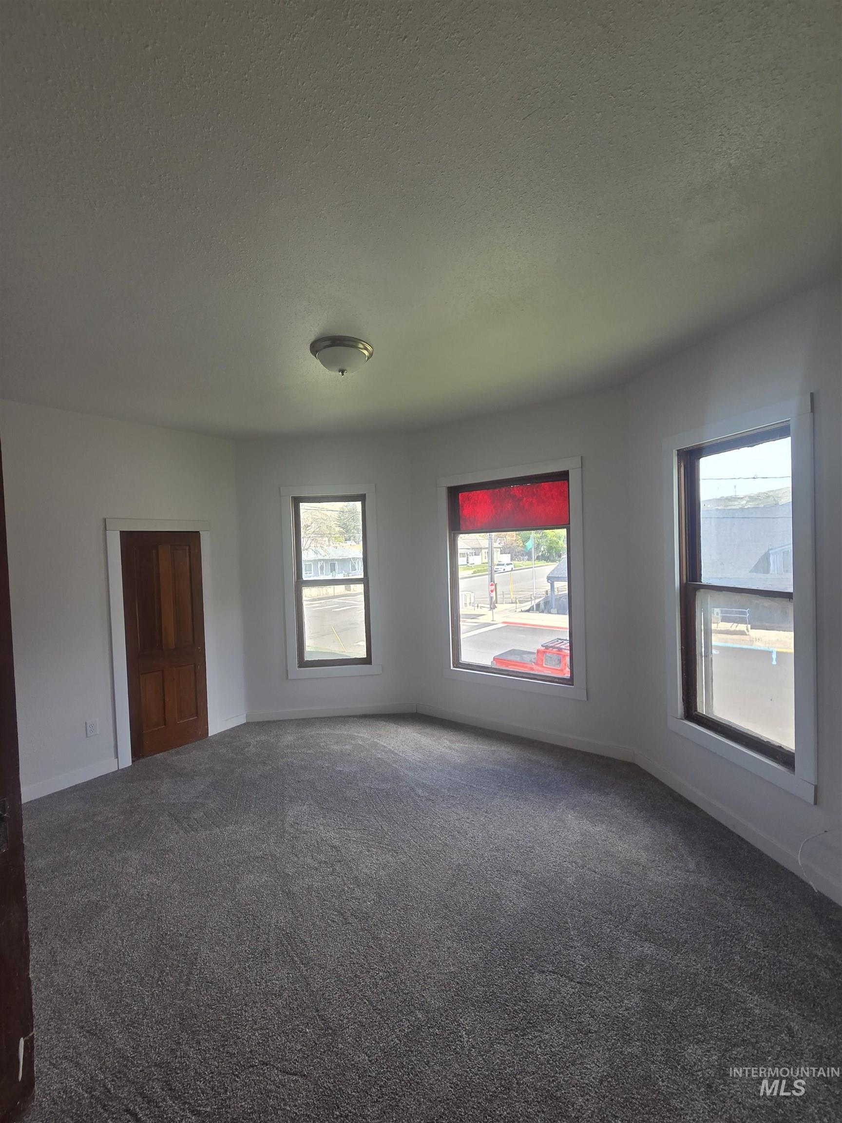 986 Columbia Street Pomeroy, WA 99347 - Photo 13 of 20 Room featuring new gray patterned carpeting, white walls, and a multi-pane window with a red blind