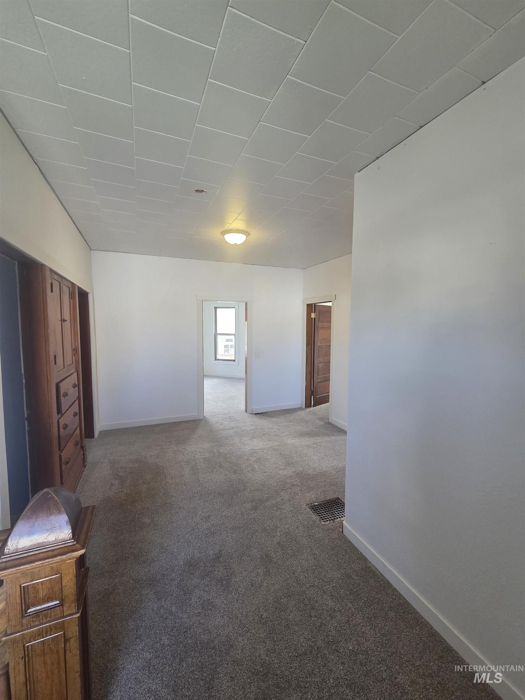 986 Columbia Street Pomeroy, WA 99347 - Photo 17 of 20 White interior walls with gray carpet flooring and white ceiling panels