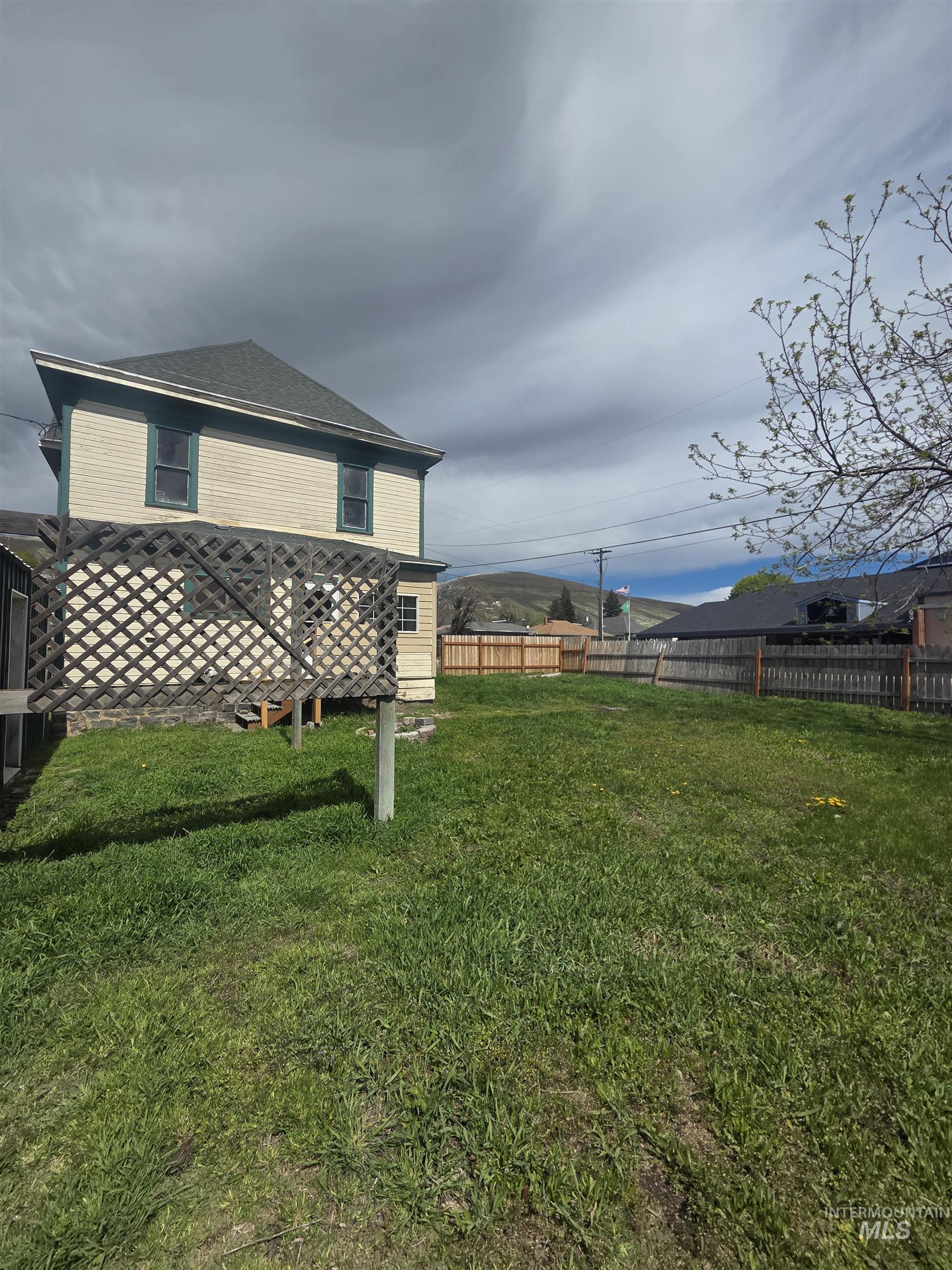 986 Columbia Street Pomeroy, WA 99347 - Photo 2 of 20 Spacious backyard featuring a sloped lawn and wooden privacy fencing