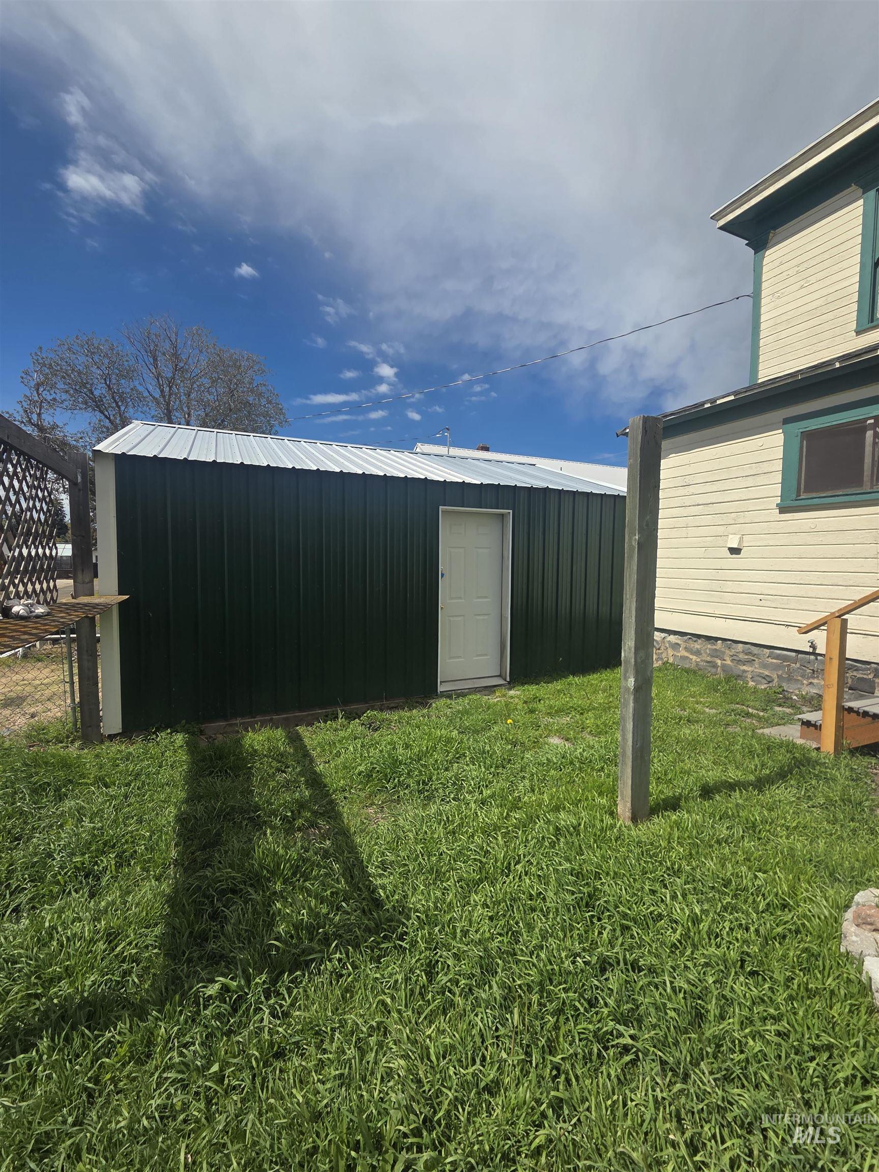 986 Columbia Street Pomeroy, WA 99347 - Photo 3 of 20 Dark green corrugated metal outbuilding with a white metal roof