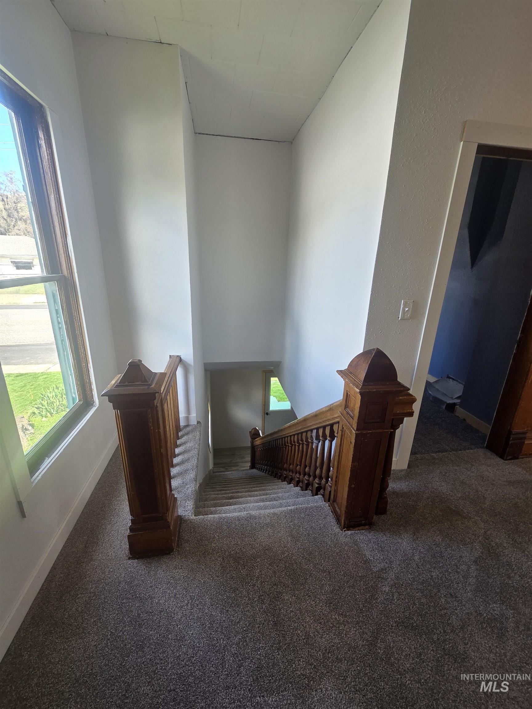 986 Columbia Street Pomeroy, WA 99347 - Photo 9 of 20 Staircase featuring ornate wood newel posts and balusters, carpeted stairs, a large window, and light wall finishes