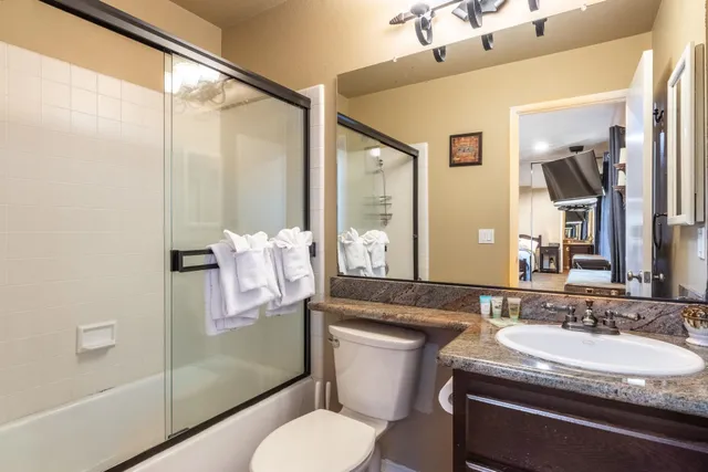 a living room with furniture kitchen view and a chandelier