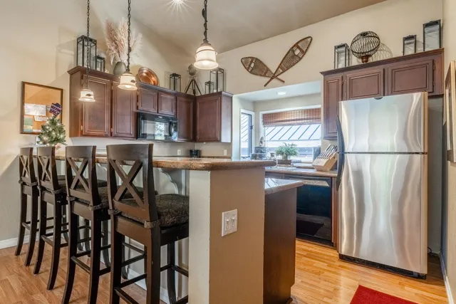 a kitchen with stainless steel appliances granite countertop a stove a sink dishwasher and microwave oven with cabinets