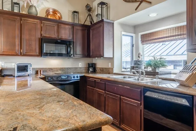 a kitchen with stainless steel appliances granite countertop a sink stove and microwave