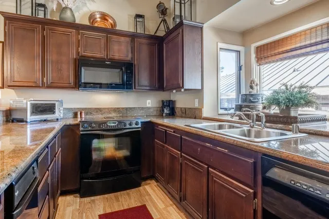 a living room with granite countertop furniture a fireplace a flat screen tv and windows