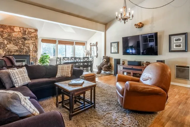 a living room with furniture a flat screen tv and a large window