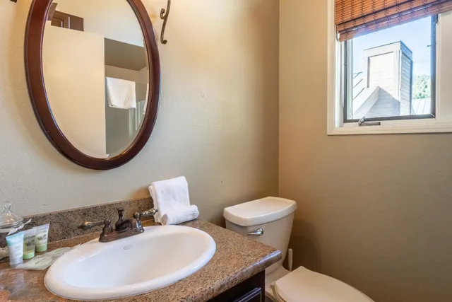 a bathroom with a toilet a sink and mirror