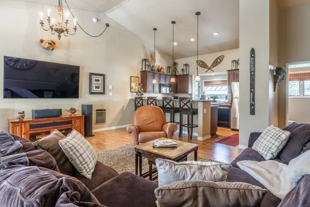a living room with furniture a flat screen tv and kitchen view