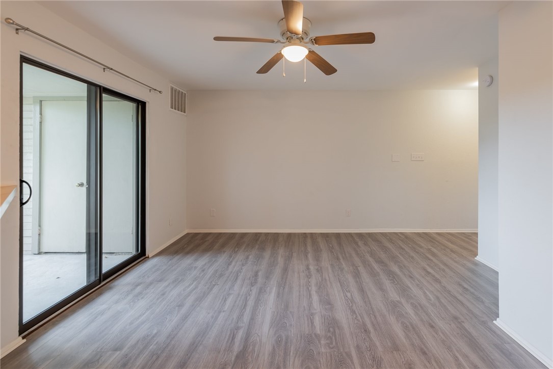 2500 Burleson Road, Unit 614 Austin, TX 78741 - Photo 3 of 20 an empty room with wooden floor fan and windows