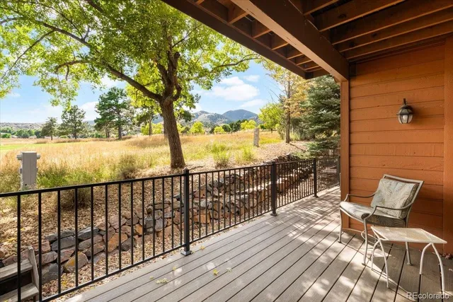 a view of a balcony with wooden floor and outdoor seating