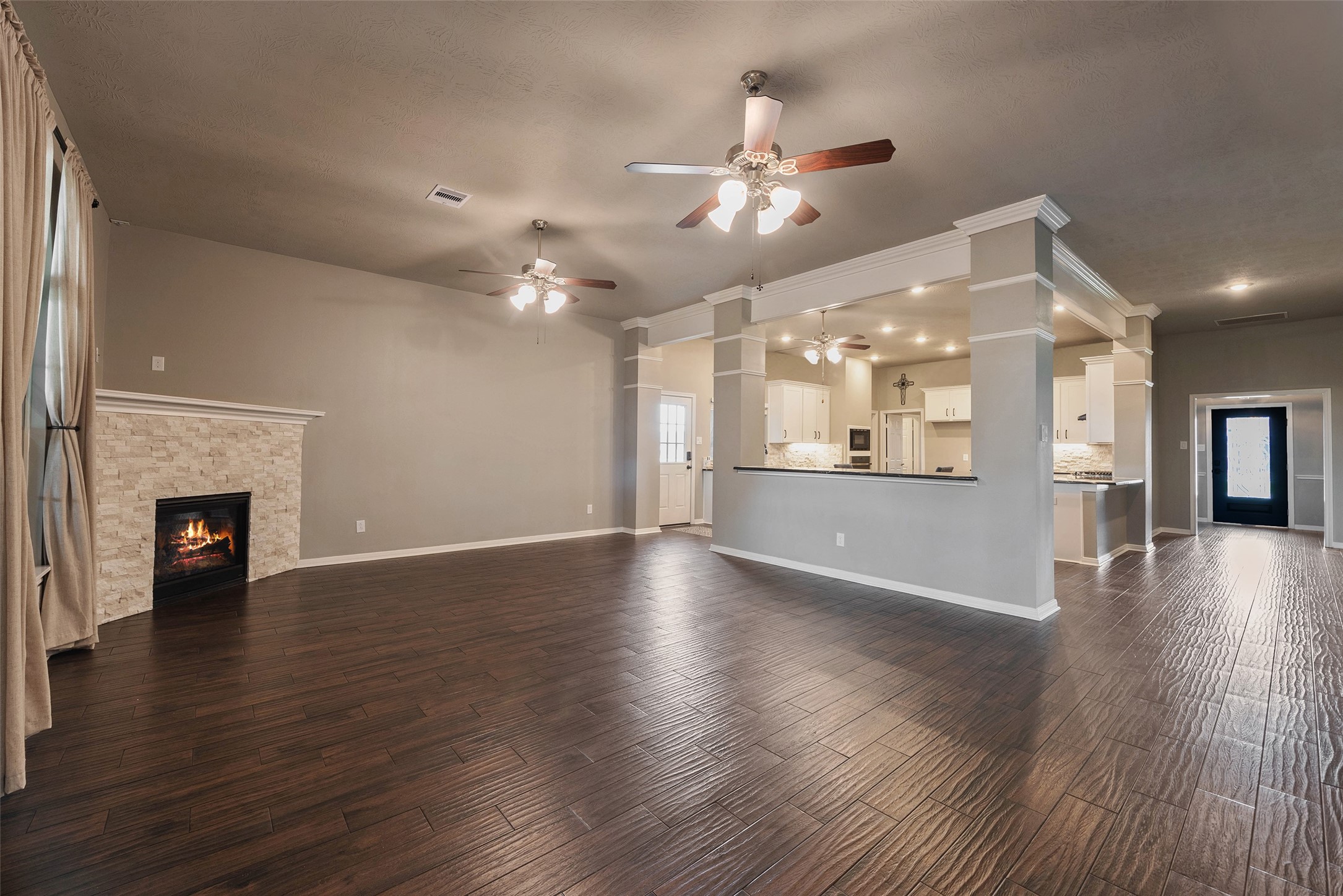 3705 Cabo Road League City, TX 77573 - Photo 5 of 43 an empty room with wooden floor fireplace and kitchen view