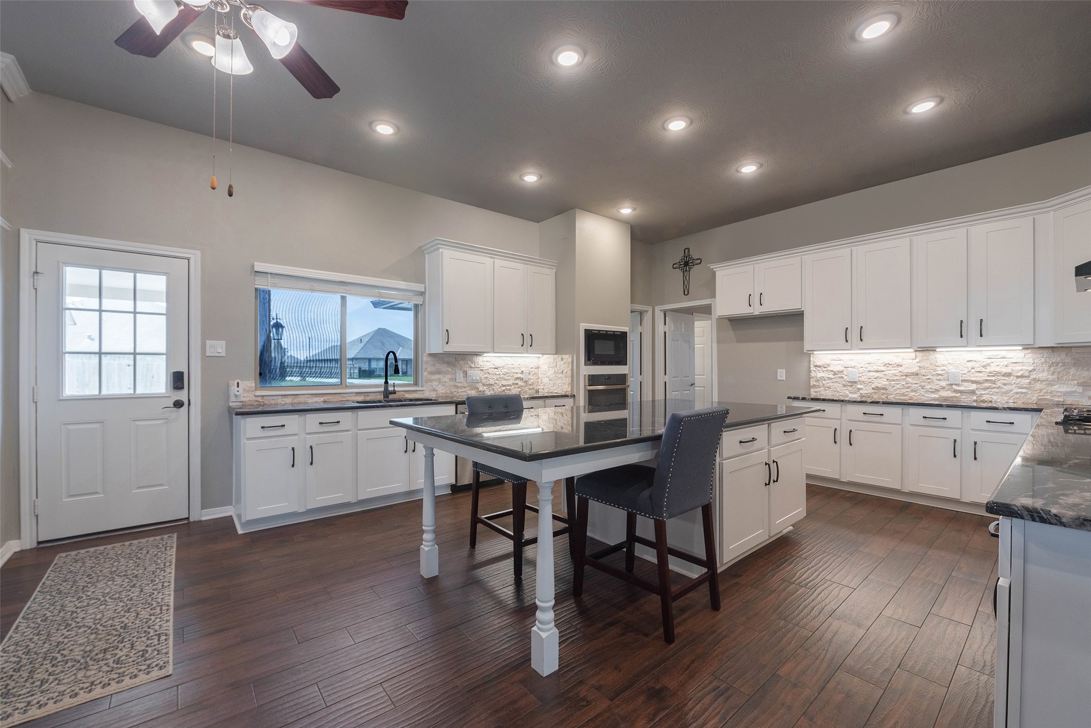 3705 Cabo Road League City, TX 77573 - Photo 8 of 43 a kitchen with stainless steel appliances kitchen island granite countertop a stove a sink a refrigerator and white cabinets with wooden floor