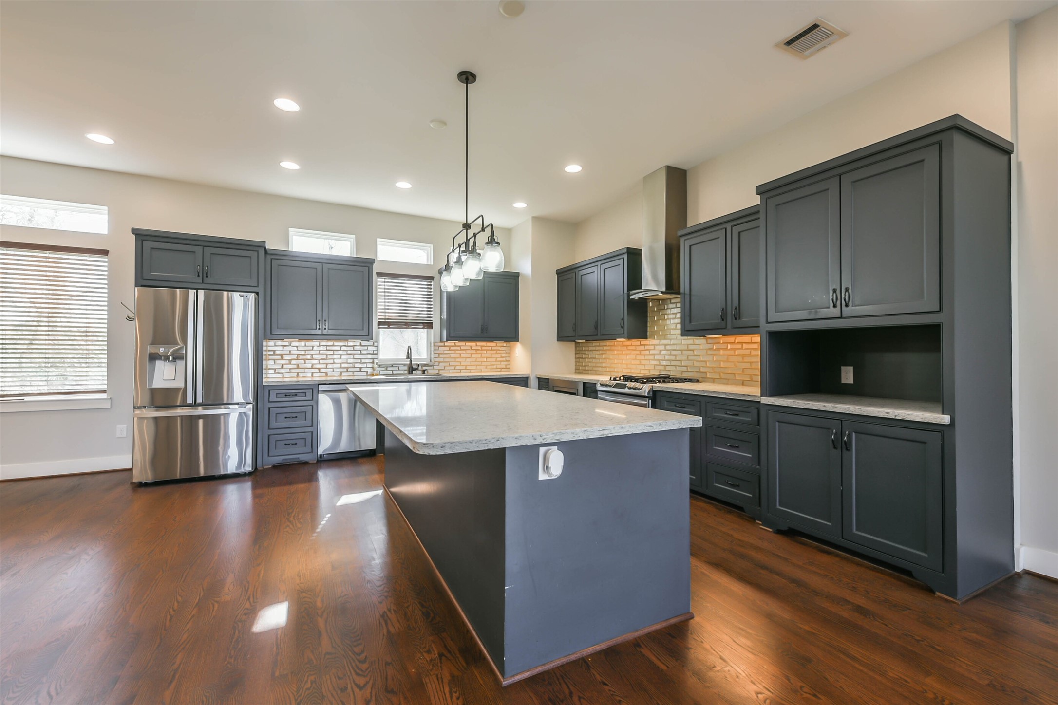 2422 Hadley Street Houston, TX 77004 - Photo 18 of 50 a kitchen with stainless steel appliances kitchen island granite countertop a stove a sink a refrigerator and a wooden floor