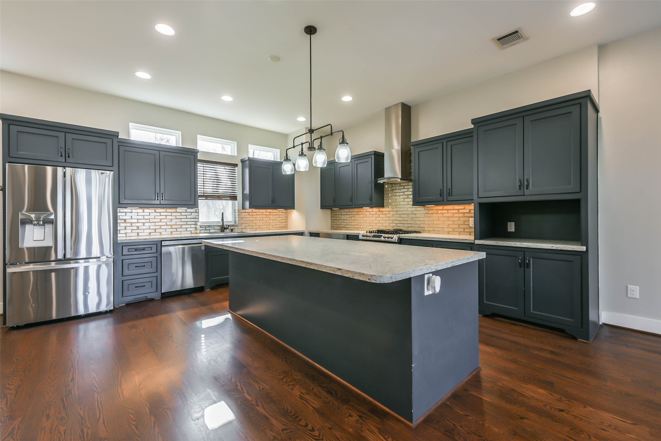 2422 Hadley Street Houston, TX 77004 - Photo 19 of 50 a kitchen with kitchen island granite countertop a sink cabinets and stainless steel appliances