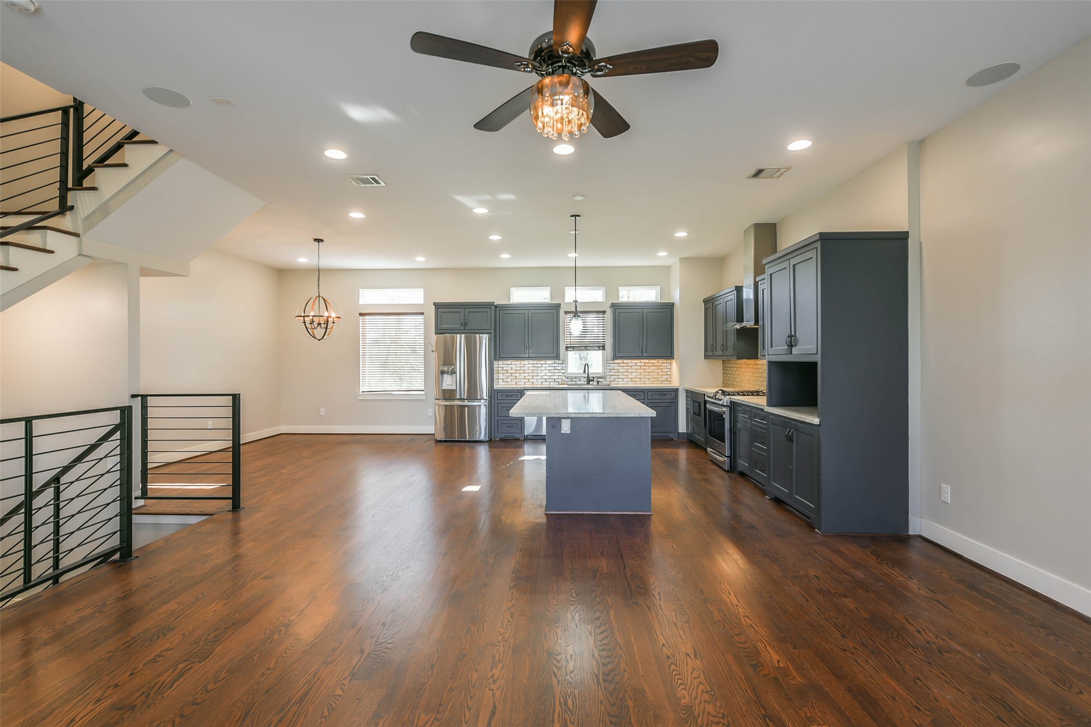 2422 Hadley Street Houston, TX 77004 - Photo 27 of 50 a open kitchen with stainless steel appliances granite countertop a refrigerator a sink dishwasher a stove and a dining table with wooden floor