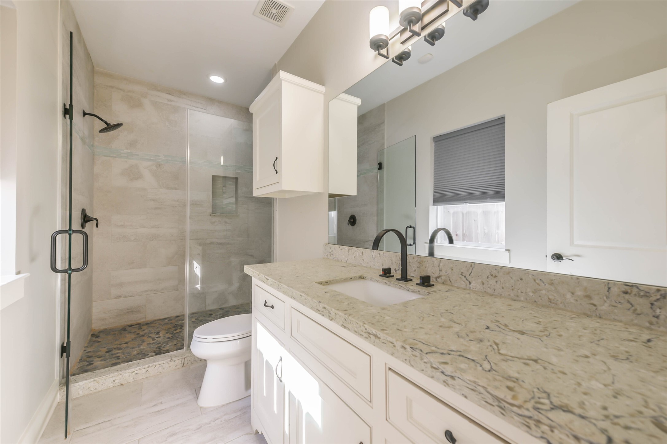 2422 Hadley Street Houston, TX 77004 - Photo 9 of 50 a bathroom with a granite countertop sink a toilet and shower