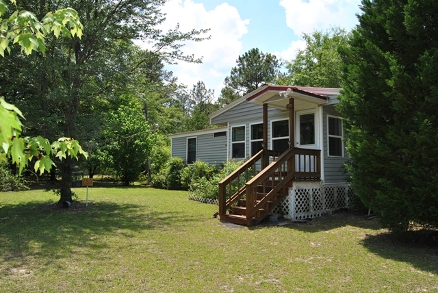 a view of a house with backyard and trees