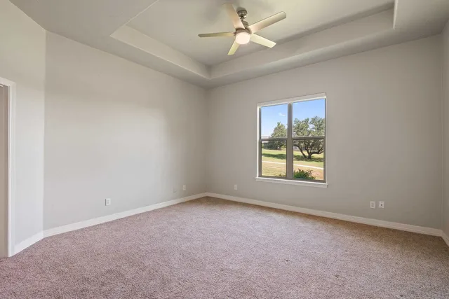 an empty room with a window and a fan