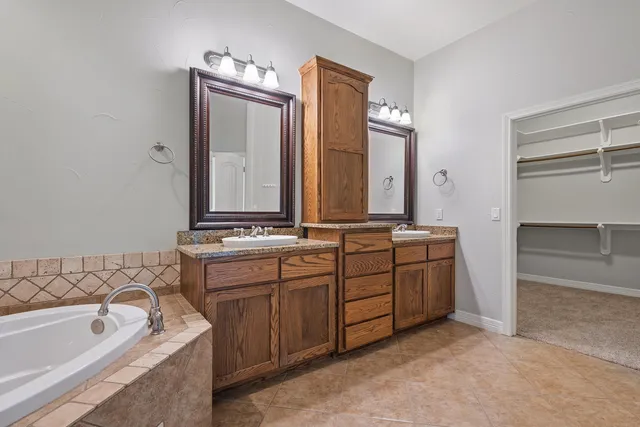 a bathroom with a tub sink and mirror