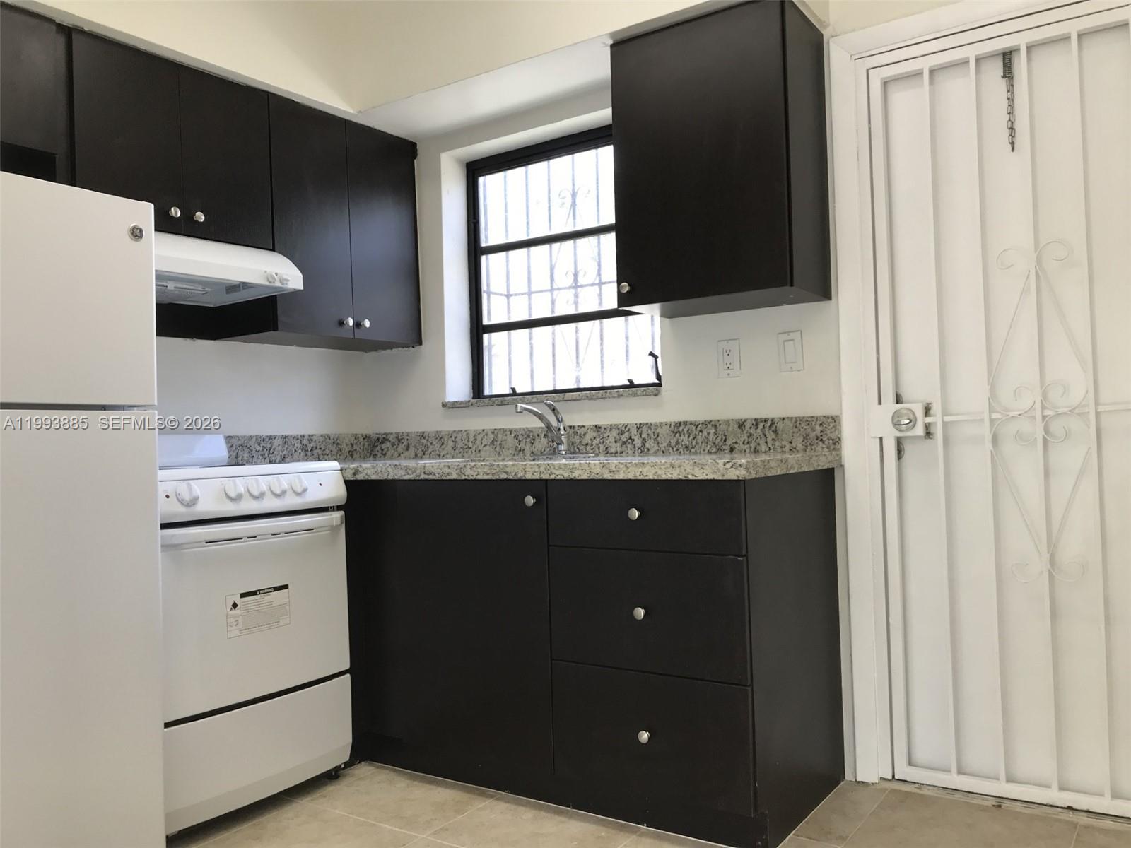 2362 Northwest 34th Street, Unit 2 Miami, FL 33142 - Photo 2 of 8 a kitchen with a sink and a refrigerator