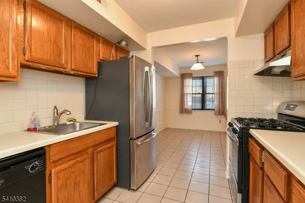 a kitchen with stainless steel appliances granite countertop a sink stove and cabinets