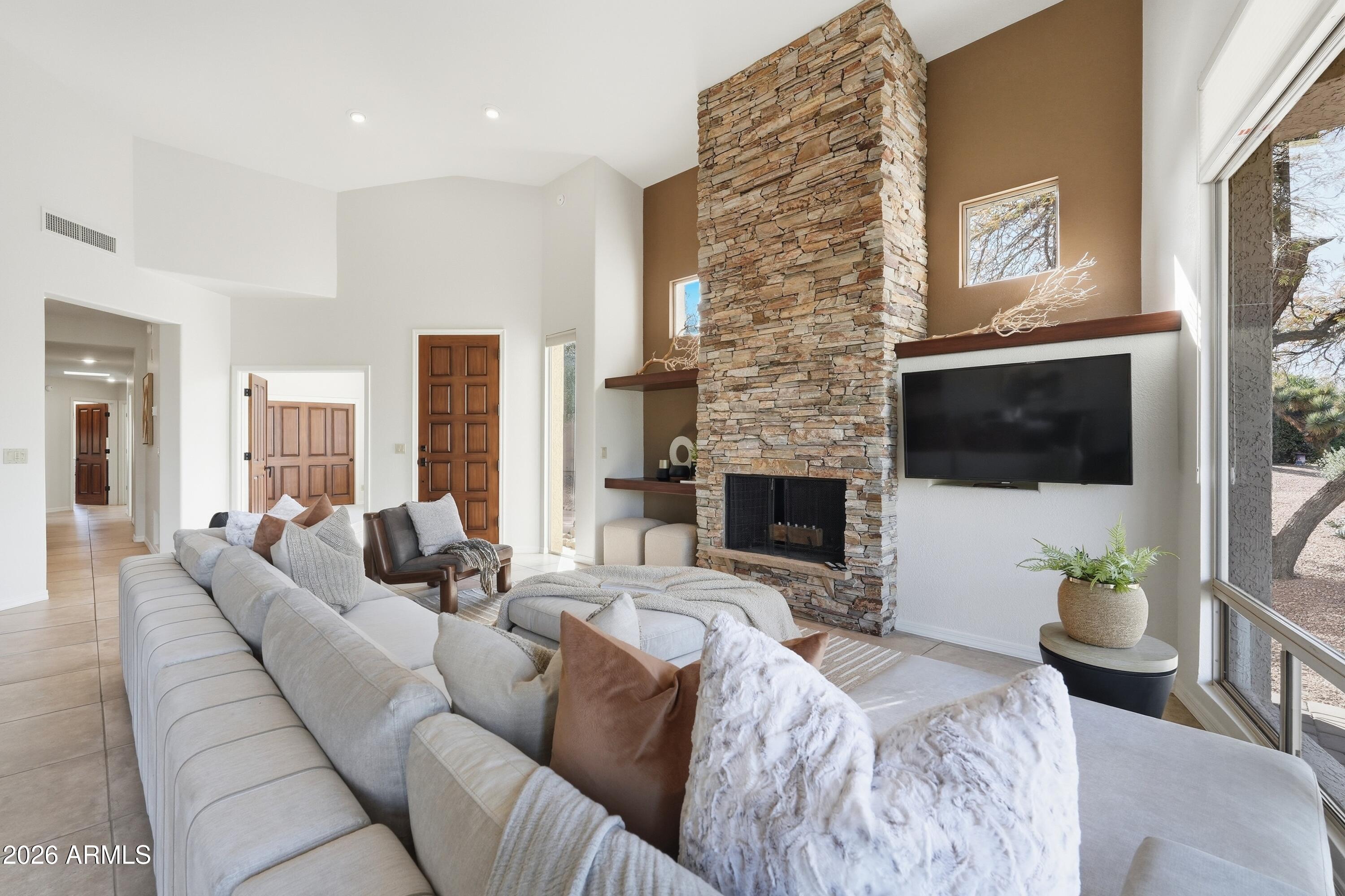 18602 Amarado Circle Rio Verde, AZ 85263 - Photo 10 of 58 a living room with furniture a flat screen tv and a fireplace