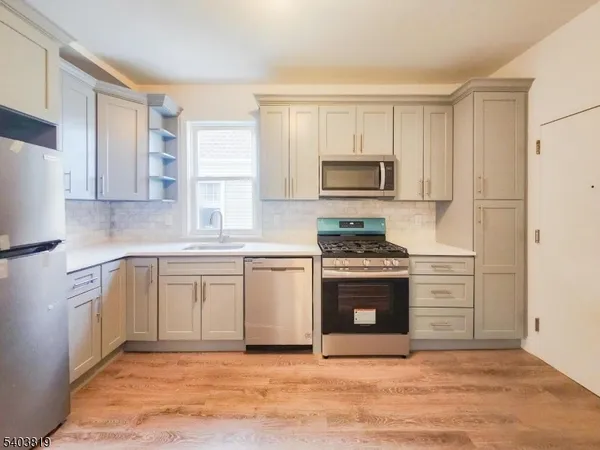 a kitchen with white cabinets and stainless steel appliances