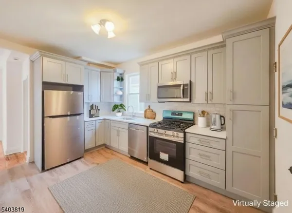 a kitchen with white cabinets and stainless steel appliances