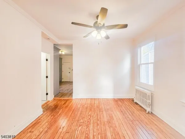 a view of a livingroom with wooden floor and a ceiling fan