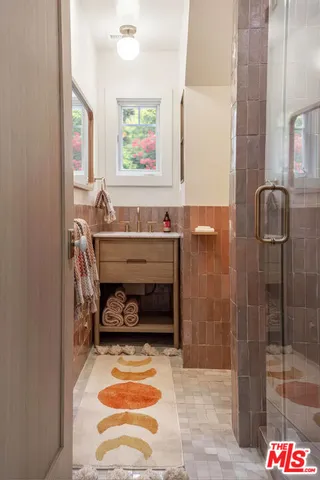 a bathroom with a sink a mirror and a shower