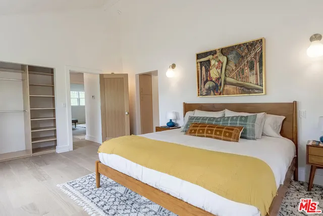 a bedroom with a bed and a painting on the wall