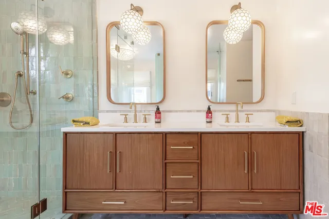 a bathroom with double vanity sinks and a mirror