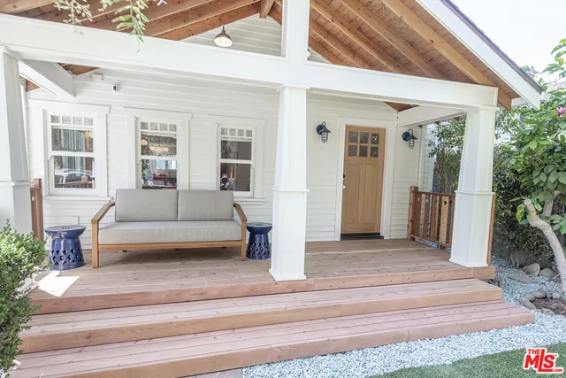 a view of a house with a couches and potted plant