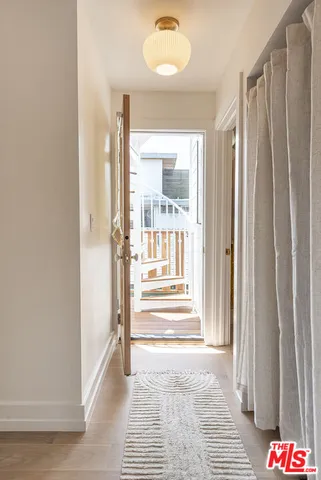a view of a hallway with wooden floor and windows