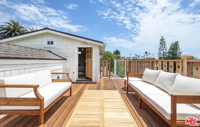 a balcony with wooden floor and furniture