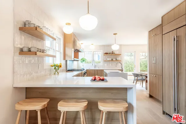 a large white kitchen with a table and chairs