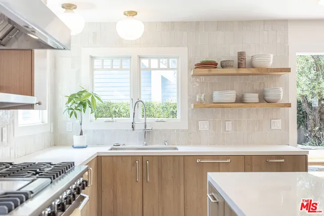 a kitchen with a stove a sink and a wooden cabinets