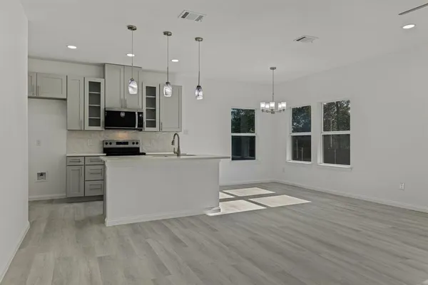 a view of kitchen with stainless steel appliances refrigerator oven microwave and stove