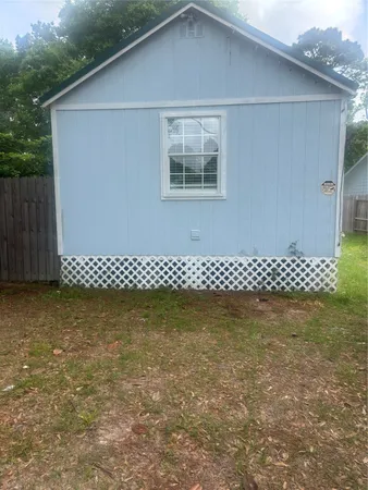 a view of a wooden house and a yard