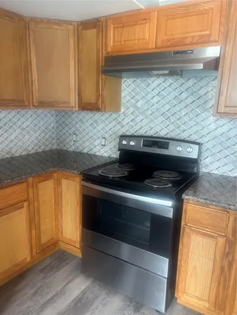 a kitchen with granite countertop cabinets stainless steel appliances and a counter space