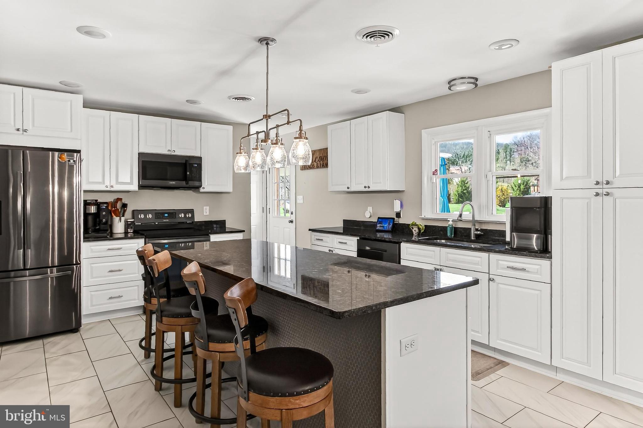 7416 Downhill Run Frederick, MD 21702 - Photo 29 of 74 a kitchen with stainless steel appliances a table chairs refrigerator and microwave
