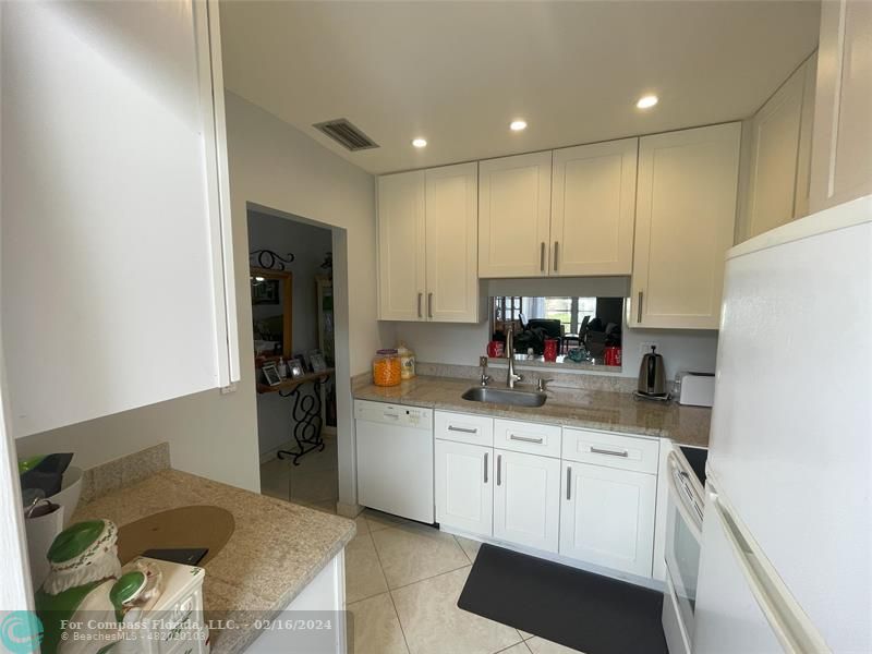 a kitchen with stainless steel appliances granite countertop a refrigerator sink and cabinets